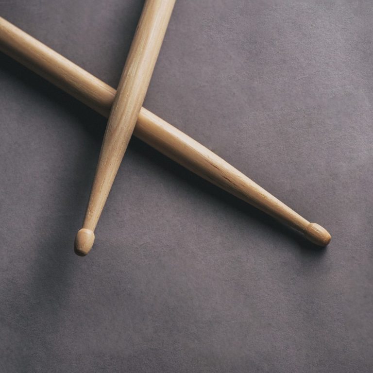 Sticks auf Boden Zwei hölzerne Trommelstöcke auf grauem Hintergrund.