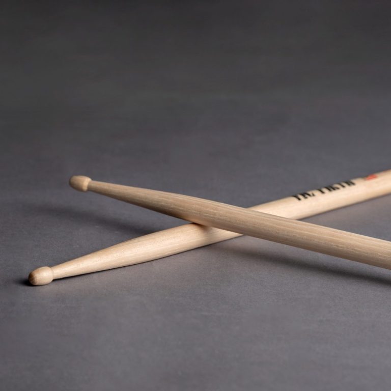 Sticks auf Boden Zwei Schlagstöcke liegen gekreuzt auf einem dunklen Hintergrund.